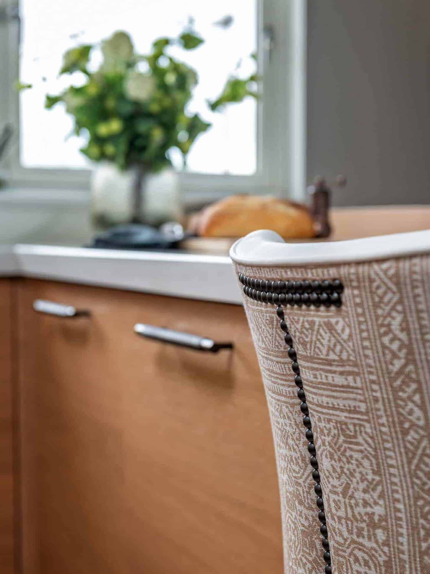 Kitchen joinery and bespoke upholstery stool detail in contemporary residential interior at Ythan Residence in Aberdeenshire